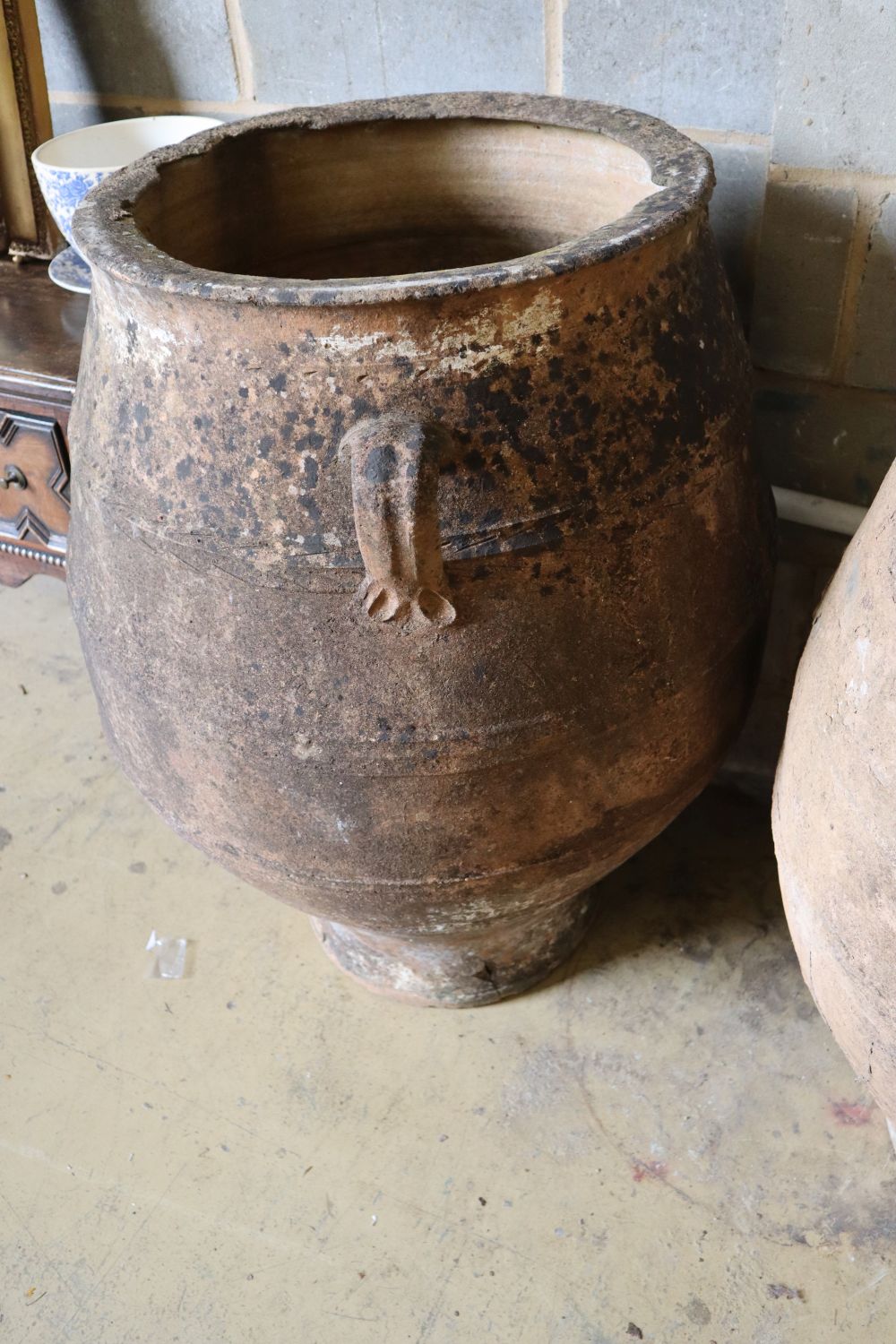 A pair of three-handled terracotta oil jars, each with ribbed sides and narrow foot, height 100cm (faults)